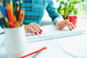 Woman writing blogs on a keyboard