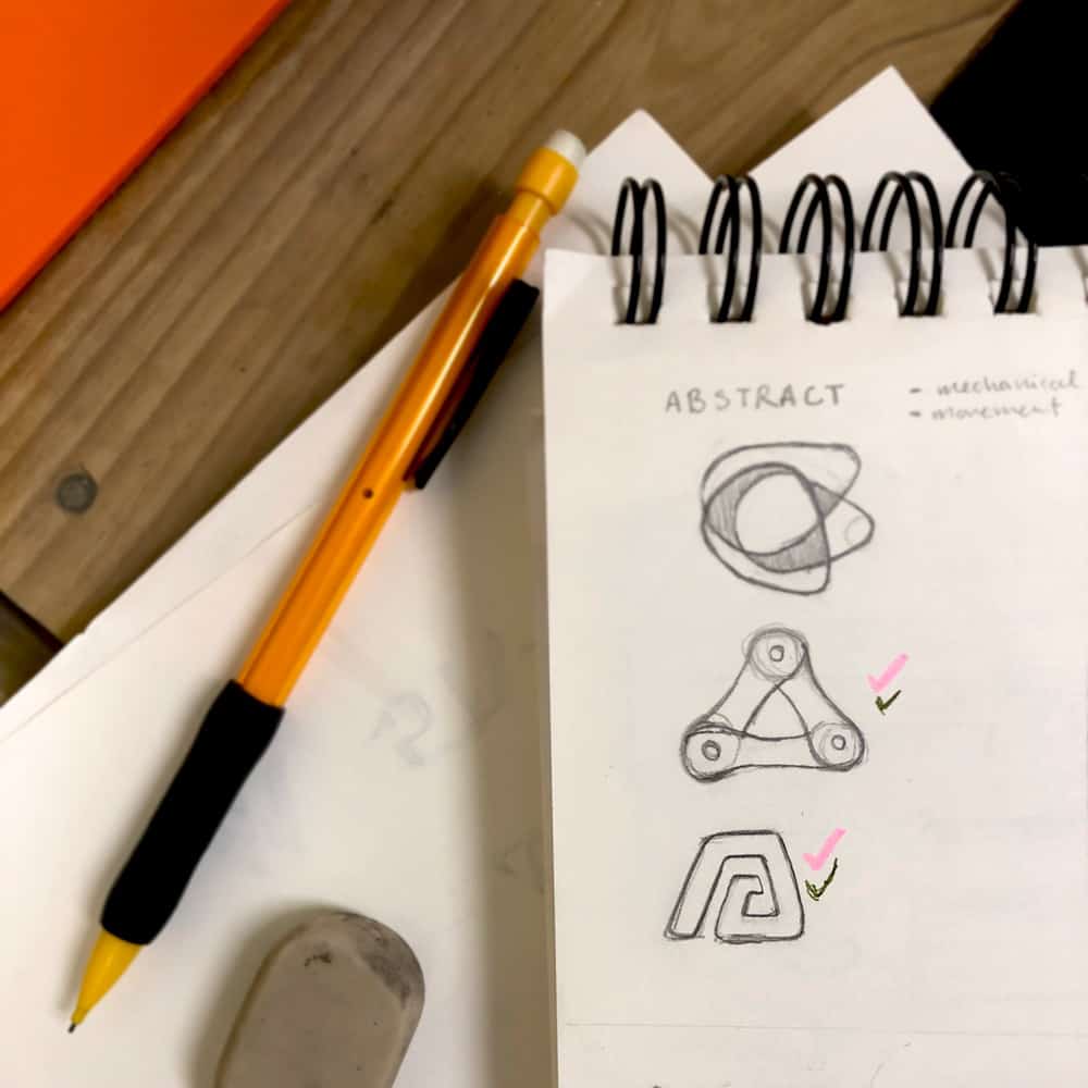 Sketches in a notebook of logo design ideas