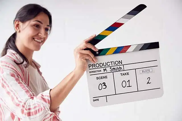 team member holds scene marker during film for building trust with customers