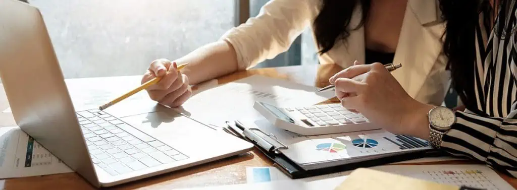 a woman at her laptop calculating business innovation costs 