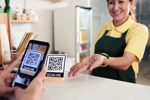 future of e-commerce example of a customer scanning a QR code at the store while an assistant helps