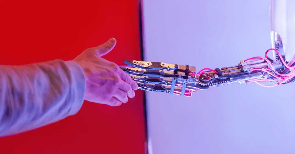 a human hand shaking a robot hand