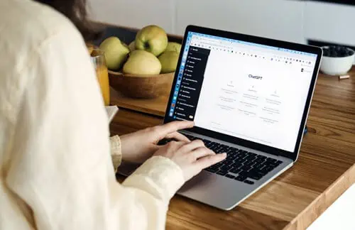 a woman using ChatGPT and AI and ML digital marketing tools on her laptop