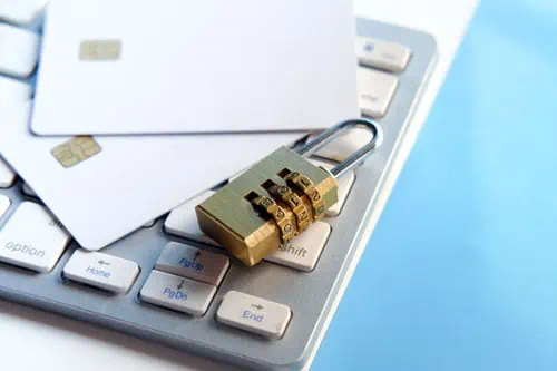 a lock on a keyboard and blank credit cards to show the importance of data privacy