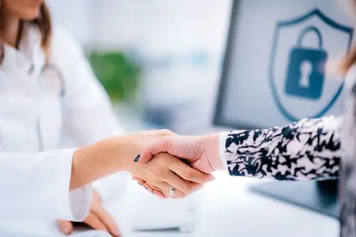 a doctor shaking hands with a patient in front of a computer screen with a lock on it