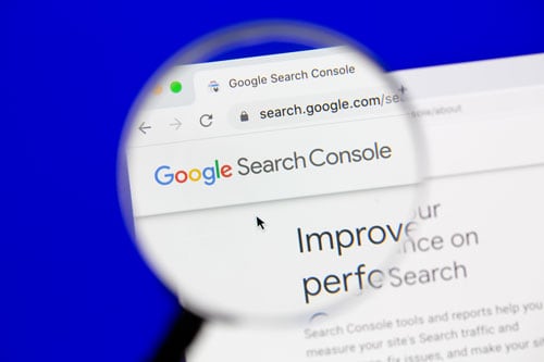 Google Search console on a laptop with an magnifying glass on top 