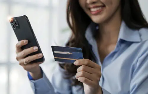 A woman making a purchase on her phone with her credit card 